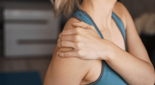 Woman holding her painful shoulder
