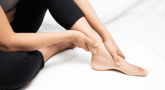 Woman holding her painful ankle